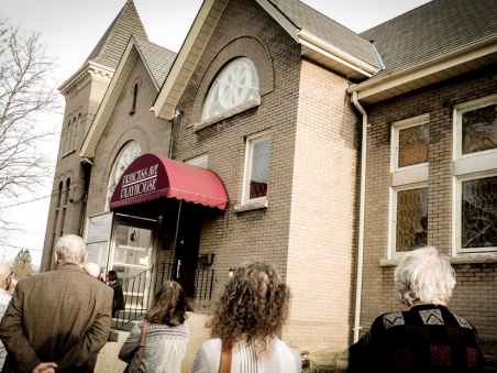 Visitors standing outside the entrance of the Elgin Theatre Guild, a historic playhouse in St. Thomas.